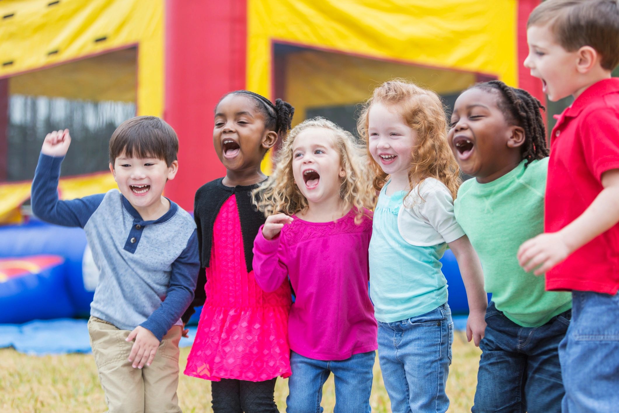 A friendly mascot waving at children during a lively birthday party